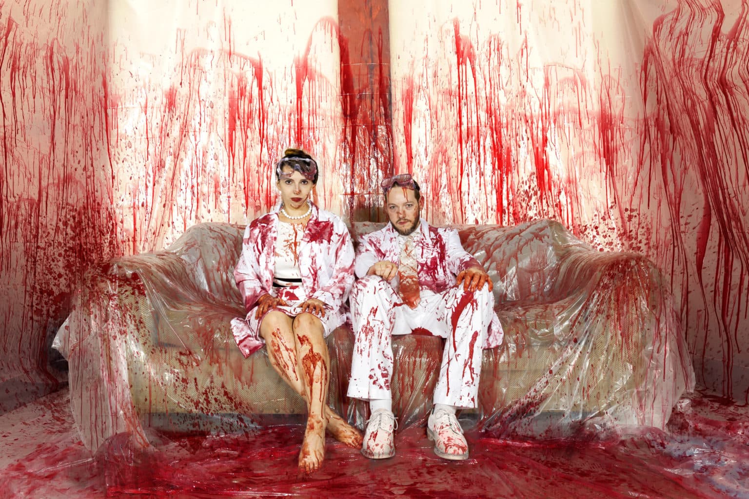 Lauren and Deven in a bloody Halloween couch scene.