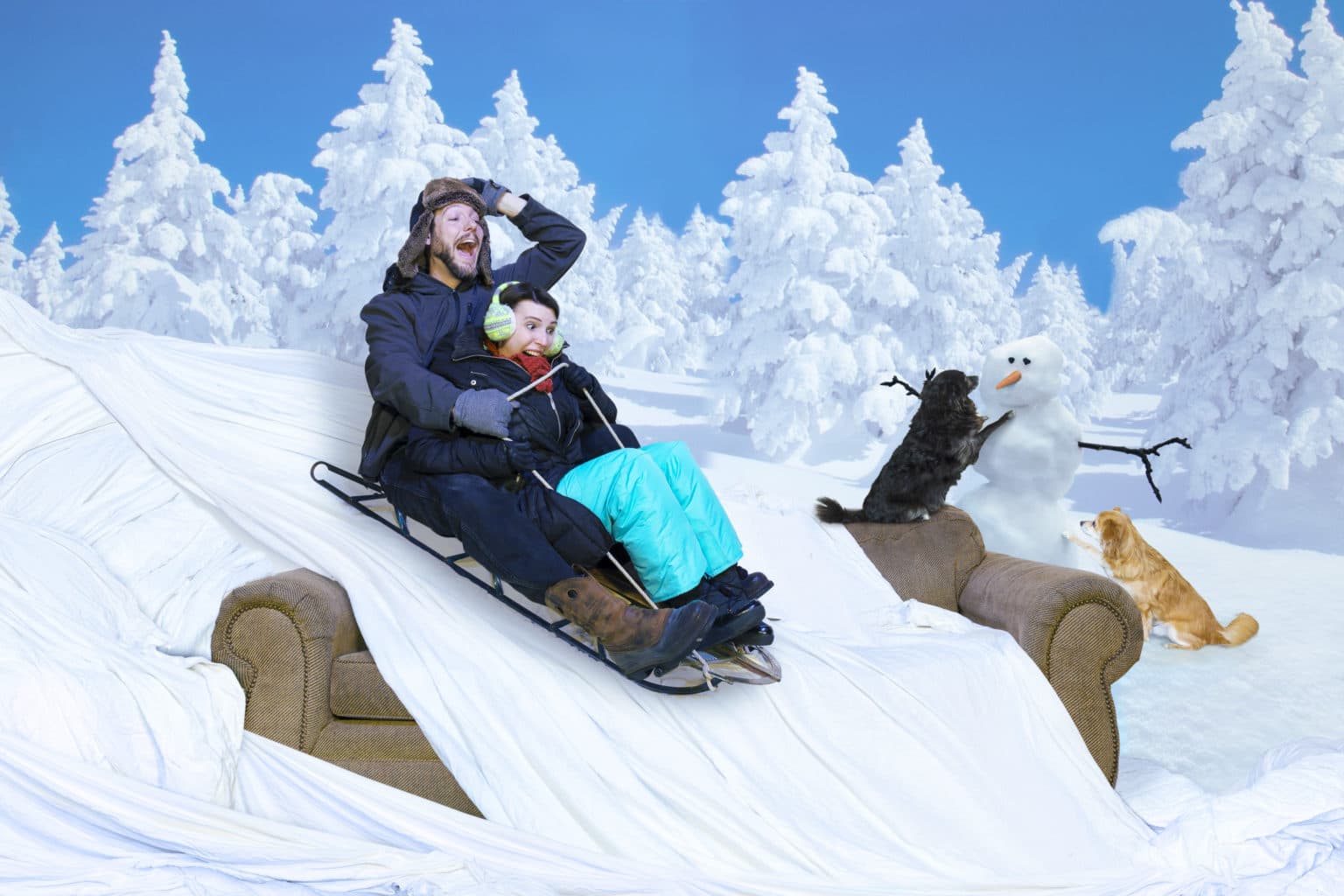 Lauren and Deven sledding on the couch in a winter scene.